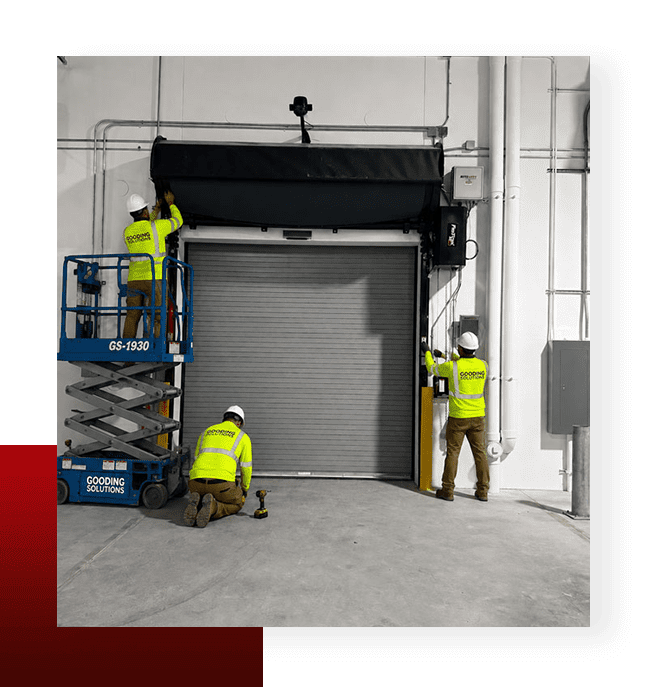 Gooding Solutions team installing a high-speed industrial roll-up door inside warehouse facility.