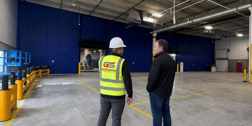 Gooding Solutions representative consulting with facility manager inside warehouse distribution center.